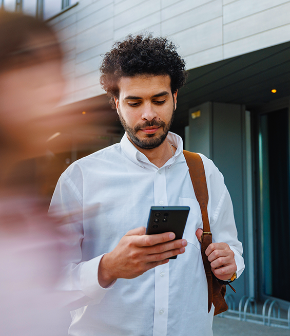 Confident man looking down at his phone in his hand