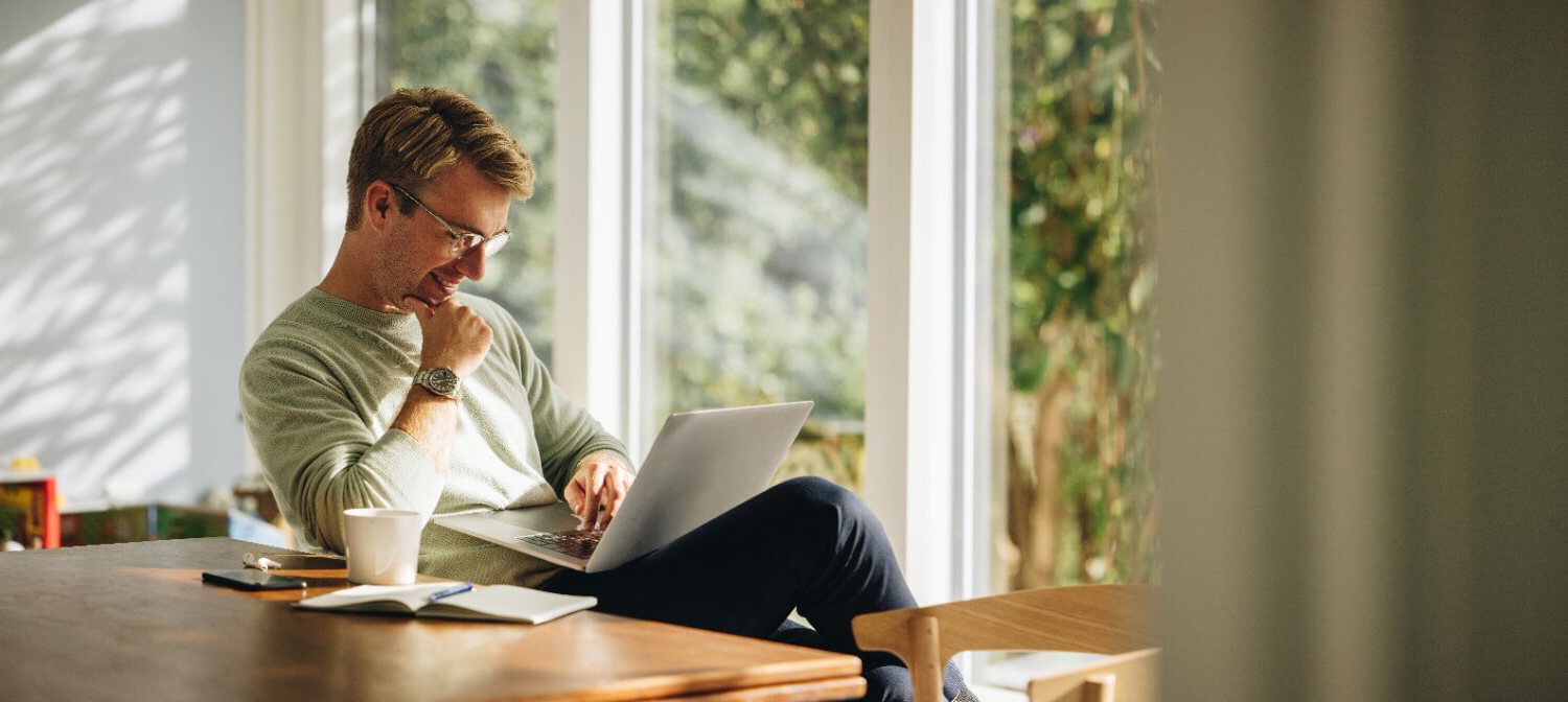 Smiling man looking down at laptop